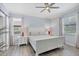 Serene bedroom with neutral tones, wood floors, and ample natural light from two windows at 12871 Cinqueterre Dr, Venice, FL 34293