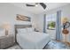 Comfortable bedroom with a ceiling fan, soft blue walls, and a large window at 12871 Cinqueterre Dr, Venice, FL 34293