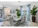 Dining room features a glass table, tufted chairs, modern chandelier, and decorative accents at 12871 Cinqueterre Dr, Venice, FL 34293