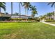 A lush entrance sign to Gran Paradiso is beautifully landscaped with palm trees, flowers, and vibrant green grass at 12871 Cinqueterre Dr, Venice, FL 34293