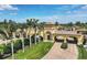 The community's gate entry features elegant architecture, mature palm trees, and meticulously manicured landscaping at 12871 Cinqueterre Dr, Venice, FL 34293