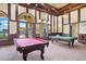The community's game room features two pool tables, high ceilings, decorative lighting, and large windows at 12871 Cinqueterre Dr, Venice, FL 34293