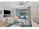 Bright living room with electric fireplace, ceiling fan, and view of the sparkling pool at 12871 Cinqueterre Dr, Venice, FL 34293
