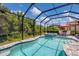 Sparkling pool and hot tub in a screened lanai offering a private backyard oasis with lush greenery at 12871 Cinqueterre Dr, Venice, FL 34293