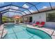 Inviting pool and spa in screened lanai featuring sun loungers, dining, and seating areas at 12871 Cinqueterre Dr, Venice, FL 34293