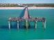 Aerial view of a pier stretching into the ocean with a beach and buildings in the background at 13016 Rinella St, Venice, FL 34293