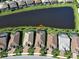 An aerial view showing homes with screened pools and manicured lawns bordering a serene lake at 13016 Rinella St, Venice, FL 34293