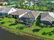 An aerial view of a lakefront community featuring lush lawns and beautiful single-Gathering homes at 13016 Rinella St, Venice, FL 34293