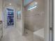 Elegant bathroom featuring a tiled walk-in shower with glass enclosure and a view into a spacious walk-in closet at 13016 Rinella St, Venice, FL 34293