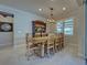 Charming dining room with an antique table, seating for eight, and decorative hutch, illuminated by a stylish chandelier at 13016 Rinella St, Venice, FL 34293