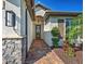 Beautiful home entrance featuring a brick walkway, garden bed, and elegant entry door at 13016 Rinella St, Venice, FL 34293