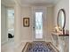 Elegant foyer with stylish console table, decorative mirror, and patterned area rug at 13016 Rinella St, Venice, FL 34293