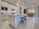 Bright, open kitchen featuring an island with seating and modern lighting at 13016 Rinella St, Venice, FL 34293