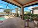 Outdoor patio area with a private swimming pool overlooking a tranquil lake, surrounded by lush tropical landscaping at 13016 Rinella St, Venice, FL 34293