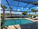 Screened-in pool and travertine lanai with palm trees and serene lake view at 13016 Rinella St, Venice, FL 34293
