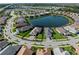An aerial view showcases a neighborhood encircling a lake, with well-maintained landscaping and neatly arranged homes at 13056 Steinhatchee Loop, Venice, FL 34293