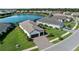 Aerial view of the home with a pond view, well manicured lawn and three car garage at 13056 Steinhatchee Loop, Venice, FL 34293