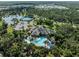 Stunning aerial view of a clubhouse, pool, and parking lot surrounded by lush greenery and nearby residences at 13056 Steinhatchee Loop, Venice, FL 34293