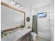 Well-lit bathroom with a white vanity, framed mirror, and shower with tub combo at 13056 Steinhatchee Loop, Venice, FL 34293