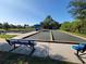 Well-maintained bocce ball courts with benches and shade structures under a clear blue sky at 13056 Steinhatchee Loop, Venice, FL 34293