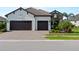 Charming home exterior with a three-car garage and well-maintained landscaping in a sunny setting at 13056 Steinhatchee Loop, Venice, FL 34293