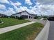 Expansive lawn shows a single-story home with a two-car garage, lush landscaping, and great curb appeal at 13056 Steinhatchee Loop, Venice, FL 34293