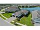 A beautiful home with a two-car garage, lush landscaping, and a paved driveway sits next to a lake at 13056 Steinhatchee Loop, Venice, FL 34293