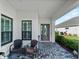 Inviting front porch with comfortable seating, a decorative rug, and stylish decor at 13056 Steinhatchee Loop, Venice, FL 34293