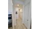 Hallway view with neutral paint, tile floors, and multiple doorways creating an open flow at 13056 Steinhatchee Loop, Venice, FL 34293