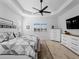 This spacious bedroom features wood-style floors, a ceiling fan, and natural lighting at 13056 Steinhatchee Loop, Venice, FL 34293