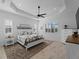 Spacious main bedroom featuring a ceiling fan, wood floors, and tray ceilings and plantation shutters at 13056 Steinhatchee Loop, Venice, FL 34293