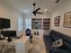 Well-lit office with built-in shelves, a comfortable couch, and a modern desk setup at 13056 Steinhatchee Loop, Venice, FL 34293