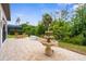 Beautiful backyard patio with a tiered fountain and well-maintained landscaping at 13280 Campanile Ct, Venice, FL 34293