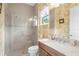 Bright bathroom with marble countertop vanity, glass shower, and decorative wallpaper at 13280 Campanile Ct, Venice, FL 34293