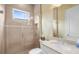 Bright bathroom featuring a glass shower, light beige tile, and patterned wallpaper at 13280 Campanile Ct, Venice, FL 34293