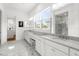 Bright bathroom featuring marble floors, double vanities, and a large window at 13280 Campanile Ct, Venice, FL 34293
