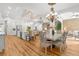 Open dining area with chandeliers, elegant chairs, light colored wood floors and seamless access to a modern kitchen at 13280 Campanile Ct, Venice, FL 34293