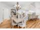 Bright dining area featuring elegant chandelier, detailed chairs and direct access to a modern, all white kitchen at 13280 Campanile Ct, Venice, FL 34293