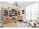 Bright home office features custom built-ins, hardwood floors, and elegant chandelier lighting at 13280 Campanile Ct, Venice, FL 34293