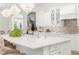 Gourmet kitchen with white cabinetry, a spacious island, and designer chandeliers at 13280 Campanile Ct, Venice, FL 34293