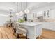 Bright, white kitchen features a large island, elegant lighting, and hardwood floors at 13280 Campanile Ct, Venice, FL 34293