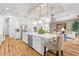 Open kitchen with an island and seating, hardwood floors, and designer light fixtures at 13280 Campanile Ct, Venice, FL 34293