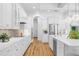 Modern kitchen featuring white cabinets, stainless steel appliances, and hardwood floors at 13280 Campanile Ct, Venice, FL 34293
