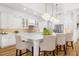 Bright kitchen with white cabinets, a large island with seating, and modern lighting at 13280 Campanile Ct, Venice, FL 34293