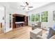 Bright living room features a large entertainment center, ample seating, and natural light from large windows at 13280 Campanile Ct, Venice, FL 34293