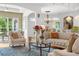 Cozy living room features a plush sofa, patterned rug, and a large window offering natural light at 13280 Campanile Ct, Venice, FL 34293
