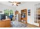 Bright home office with classic desk, ceiling fan, built in bookshelves and a large sunny window at 13280 Campanile Ct, Venice, FL 34293