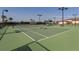 Well-maintained tennis court with night lighting and a shaded seating area at 13280 Campanile Ct, Venice, FL 34293