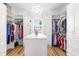 Large walk-in closet with custom shelving, wood floors, and window at 13280 Campanile Ct, Venice, FL 34293