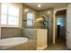 Well-lit bathroom features a large shower, a soaking tub, and tiled walls at 136 Positano Trl, Nokomis, FL 34275